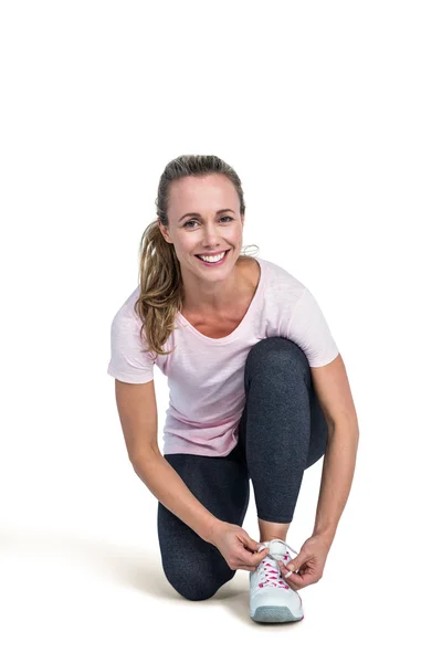 Retrato de mulher desportiva feliz amarrando cadarço — Fotografia de Stock