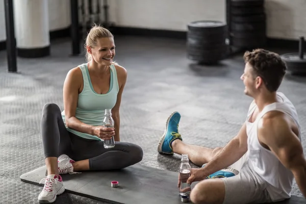 Sitting young couple drinking water — Stock Photo, Image