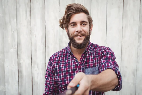 Portrait of hipster using selfie stick — Stock Photo, Image