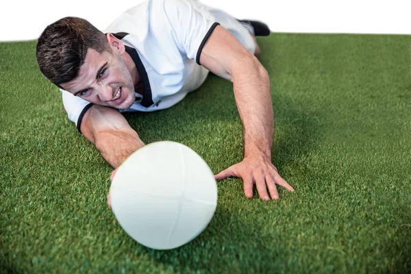 Mann legt sich hin, während er Ball hält — Stockfoto