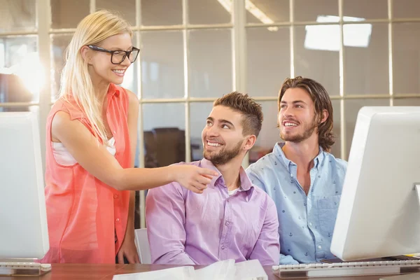 Gelukkig mannelijke collega's kijken naar zakenvrouw — Stockfoto