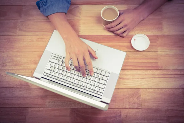 Homem segurando chá enquanto trabalhava no laptop — Fotografia de Stock