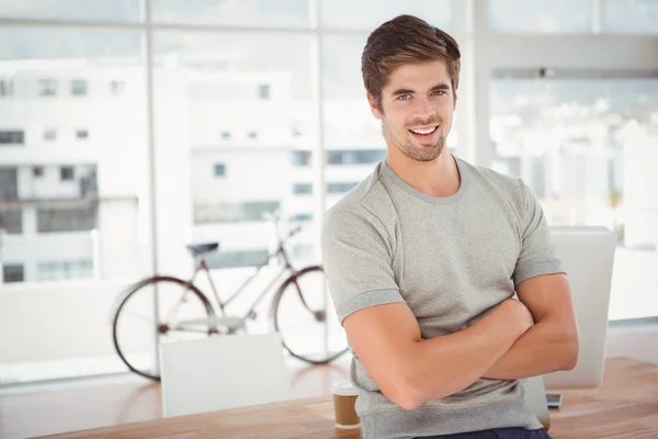 Gelukkig hipster met gekruiste armen leunend op Bureau — Stockfoto