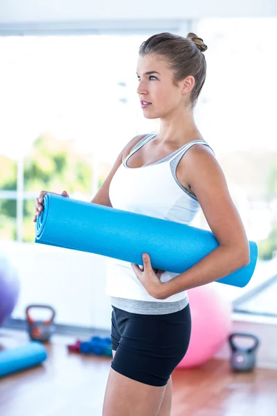 Focused woman holding yoga mat — ストック写真