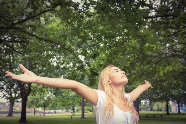 Женщина с поднятыми руками в парке — стоковое фото