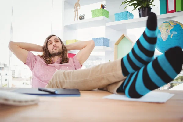 Hipster vila med ben på skrivbord i office — Stockfoto