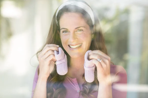 Retrato de mulher feliz com sapatos de bebê — Fotografia de Stock