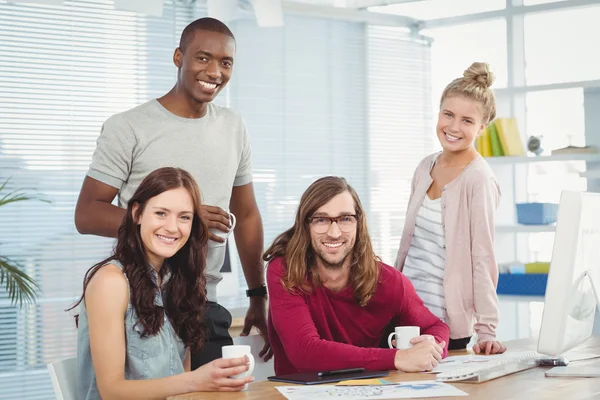 Portrait of smiling business team at computer desk — Stock Photo, Image