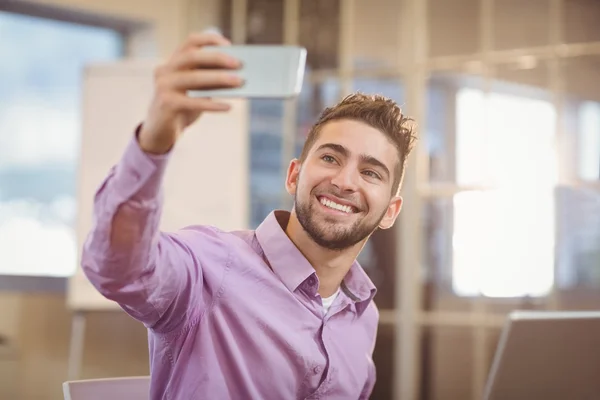 Empresário tirando selfie em escritório criativo — Fotografia de Stock