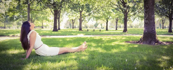Jonge vrouw ontspannen op grasland — Stockfoto