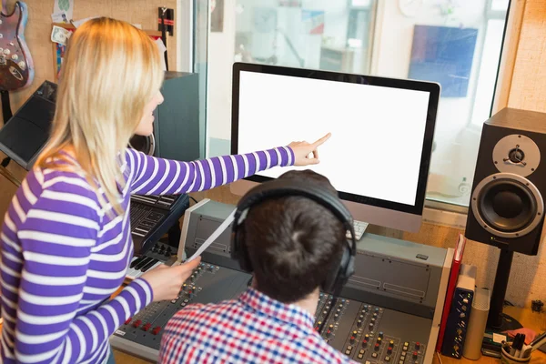 Female employee explaining male radio host on screen — Stock Photo, Image