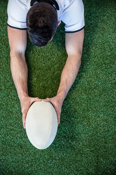 Hoge hoekmening van man met rugbybal met beide handen — Stockfoto