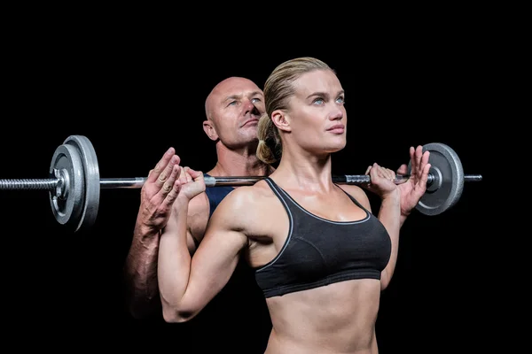 Crossfit を持ち上げるため女性を助けるトレーナー — ストック写真