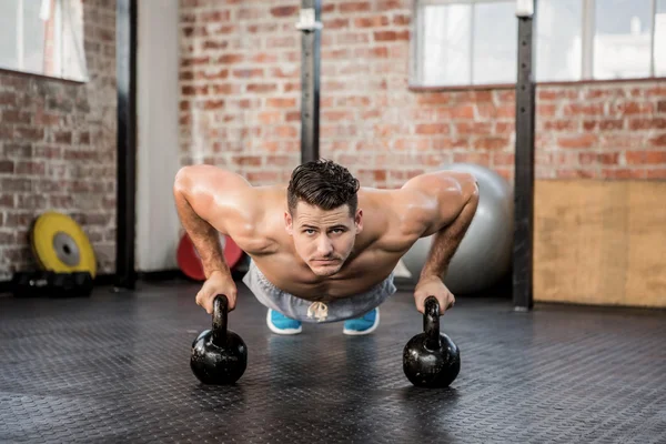 Portrait of man doing push ups with kettlebell — Stock Photo, Image