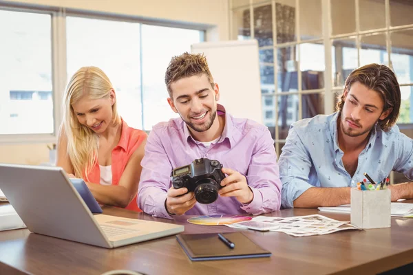 Affärskvinna tittar på kameran med kollegor som arbetar — Stockfoto