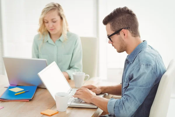 Ernstige man en vrouw die op laptop werkt — Stockfoto