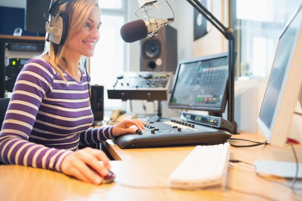 Hôte radio féminin utilisant un ordinateur pendant la diffusion — Photo