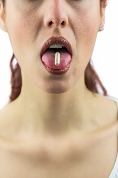 Woman with pill in mouth — Stock Photo, Image