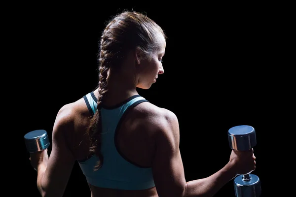 Vista trasera de la mujer haciendo ejercicio con pesas — Foto de Stock