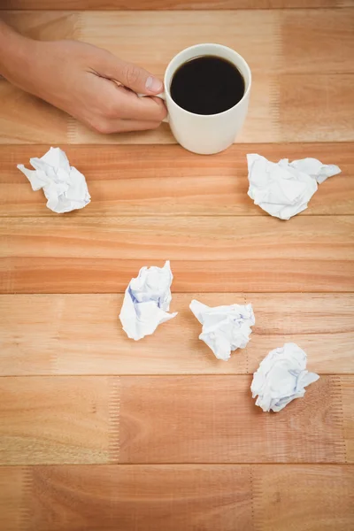 Affärsman innehar svart kaffekopp på skrivbord — Stockfoto