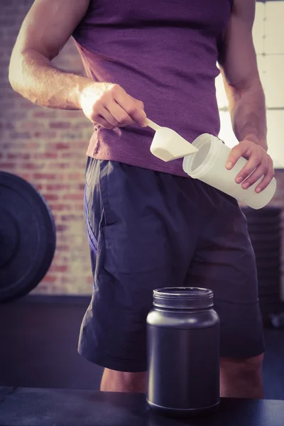 Midsection of man putting supplement into bottle — Stock Photo, Image