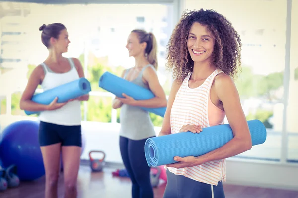 Portrait of woman holding yoga mat and smiling — Stock Photo, Image
