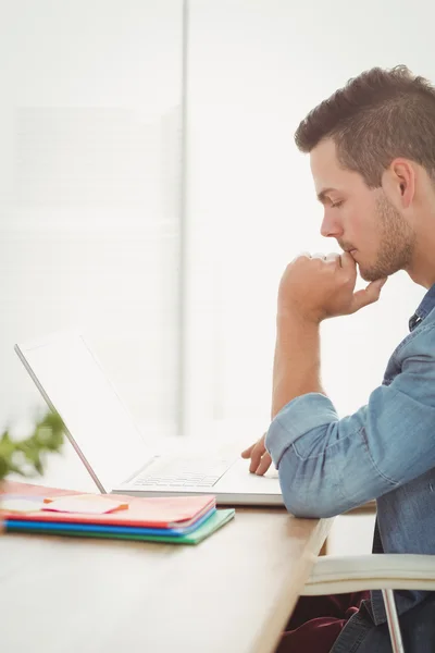 Doordachte jonge man met laptop — Stockfoto