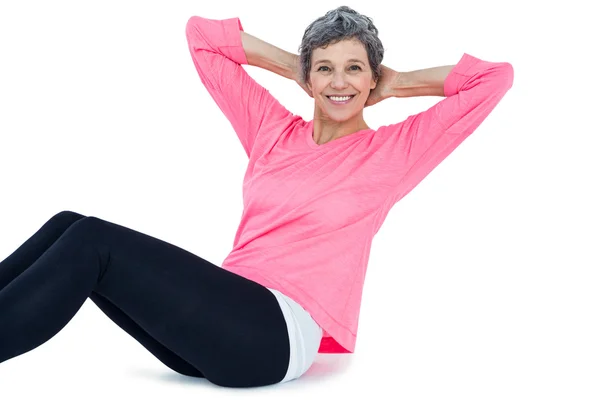 Porträt einer reifen Frau, die Sit-ups macht — Stockfoto