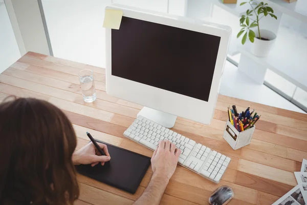 Hipster with graphics tablet at computer desk — Stock Photo, Image