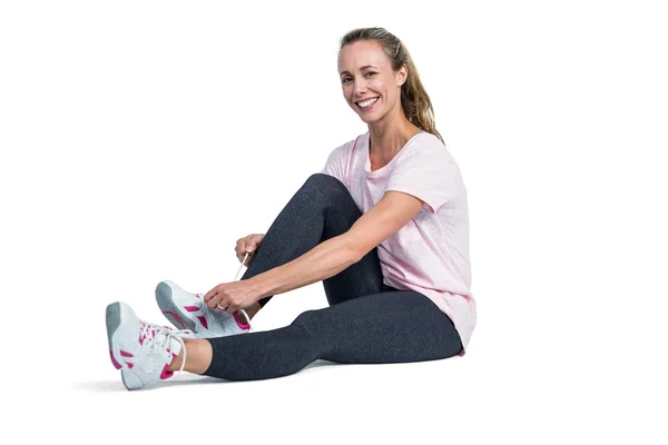 Portrait of sporty woman smiling while tying shoelace — Stock Photo, Image