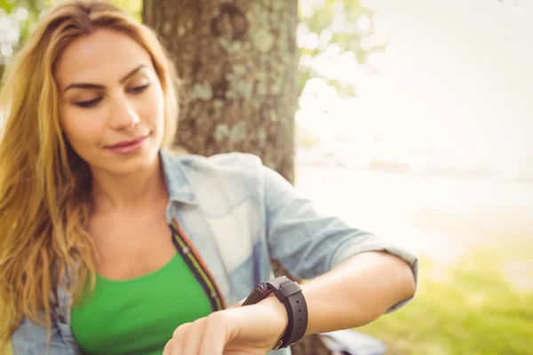 Donna sorridente toccare orologio intelligente — Foto Stock