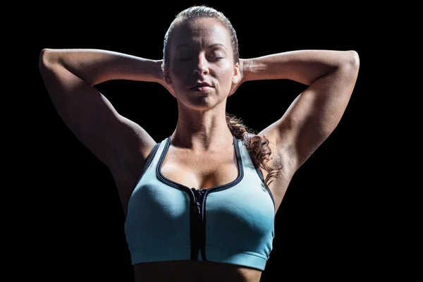 Sportliche Frau entspannt sich mit den Händen hinter dem Kopf — Stockfoto