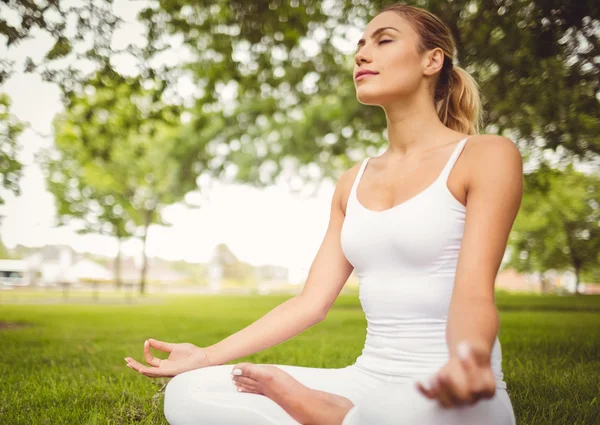 Mujer meditando mientras está sentada en pose de loto —  Fotos de Stock