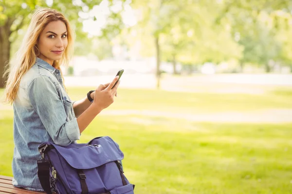 Retrato de mujer sosteniendo teléfono inteligente en el parque — Foto de Stock
