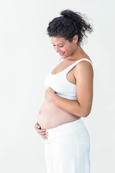 Lächelnde Schwangere berührt Bauch — Stockfoto