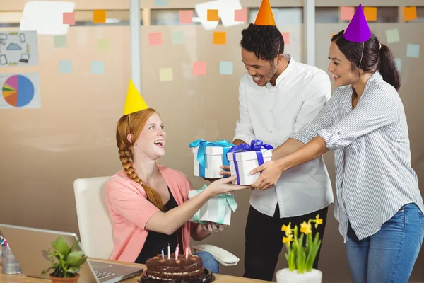 Усміхнені колеги дарують подарунки на день народження — стокове фото