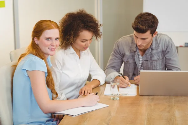 Glimlachende zakenvrouw met collega's in de vergadering — Stockfoto