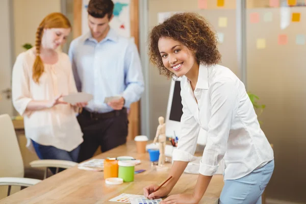 Geschäftsfrau steht mit Kollegen am Tisch — Stockfoto