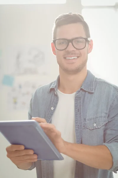 Porträtt av lycklig man bär glasögon medan du håller digital t — Stockfoto