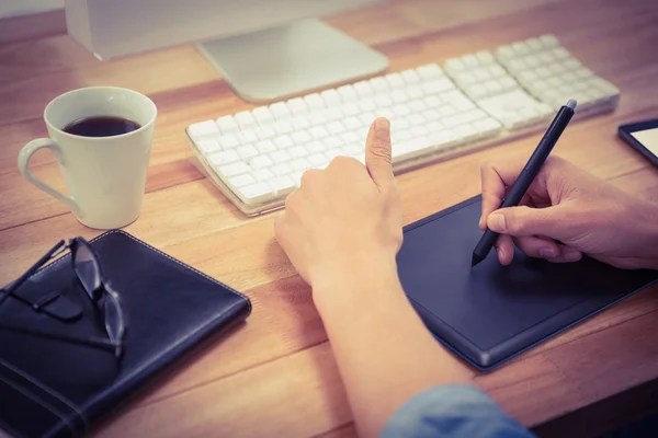 Hipster using graphics tablet on desk in office — Stock Photo, Image