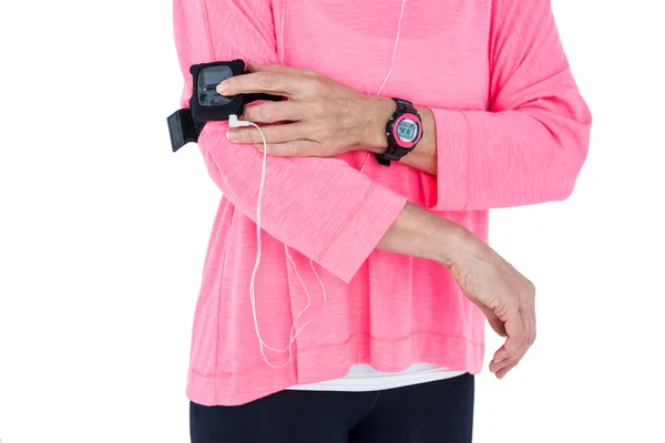 Mid section of woman using mp3 player in armband — Stock Photo, Image