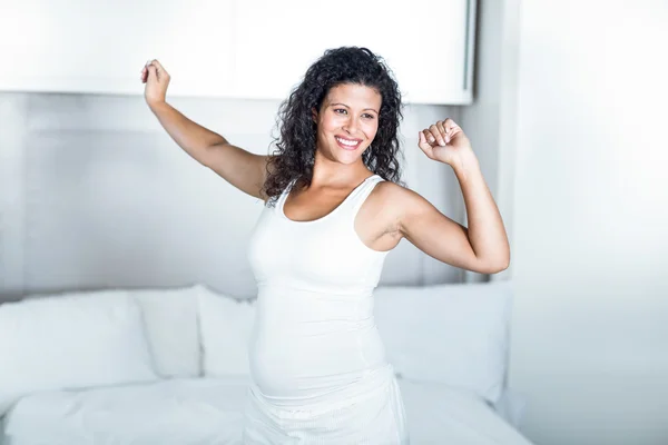 Szép terhes nő, nyúlik a hálószobában — Stock Fotó