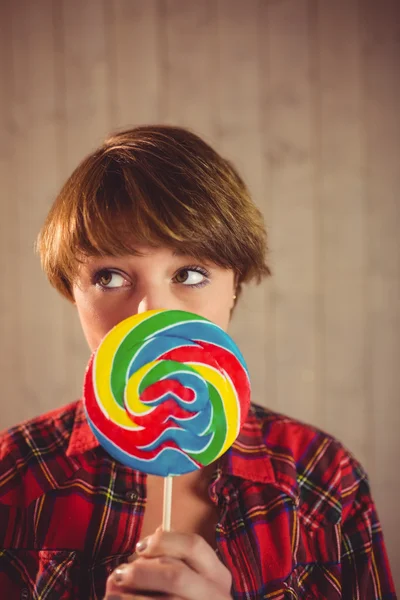 Vacker kvinna gömmer sig hennes ansikte bakom lollipop — Stockfoto