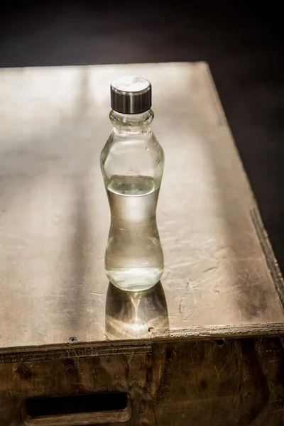 Fles water op plyo box — Stockfoto