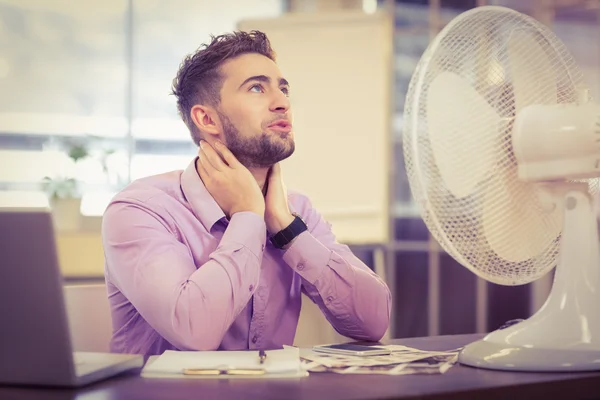 Businessman looking up while sitting at desk — Stock Photo, Image