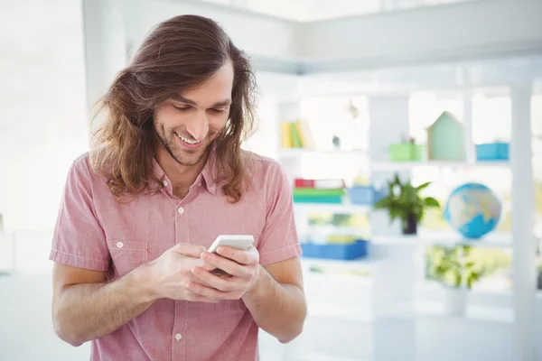 Hipster sonriendo mientras usa el teléfono móvil — Foto de Stock