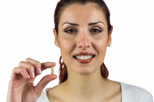 Close-up portrait of happy woman holding pill — Stock Photo, Image