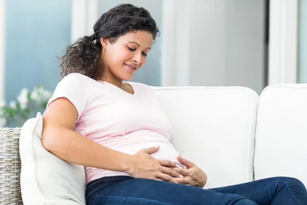 Mulher feliz no sofá em casa — Fotografia de Stock