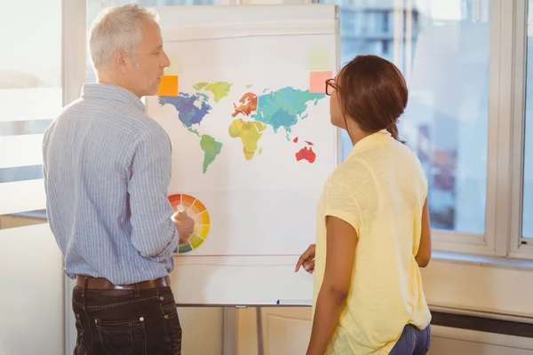 Empresários discutindo sobre mapa do mundo no quadro branco — Fotografia de Stock