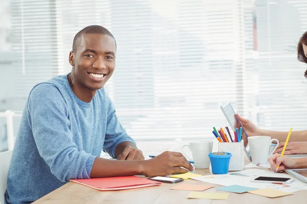 Портрет улыбающегося человека во время работы за столом — стоковое фото
